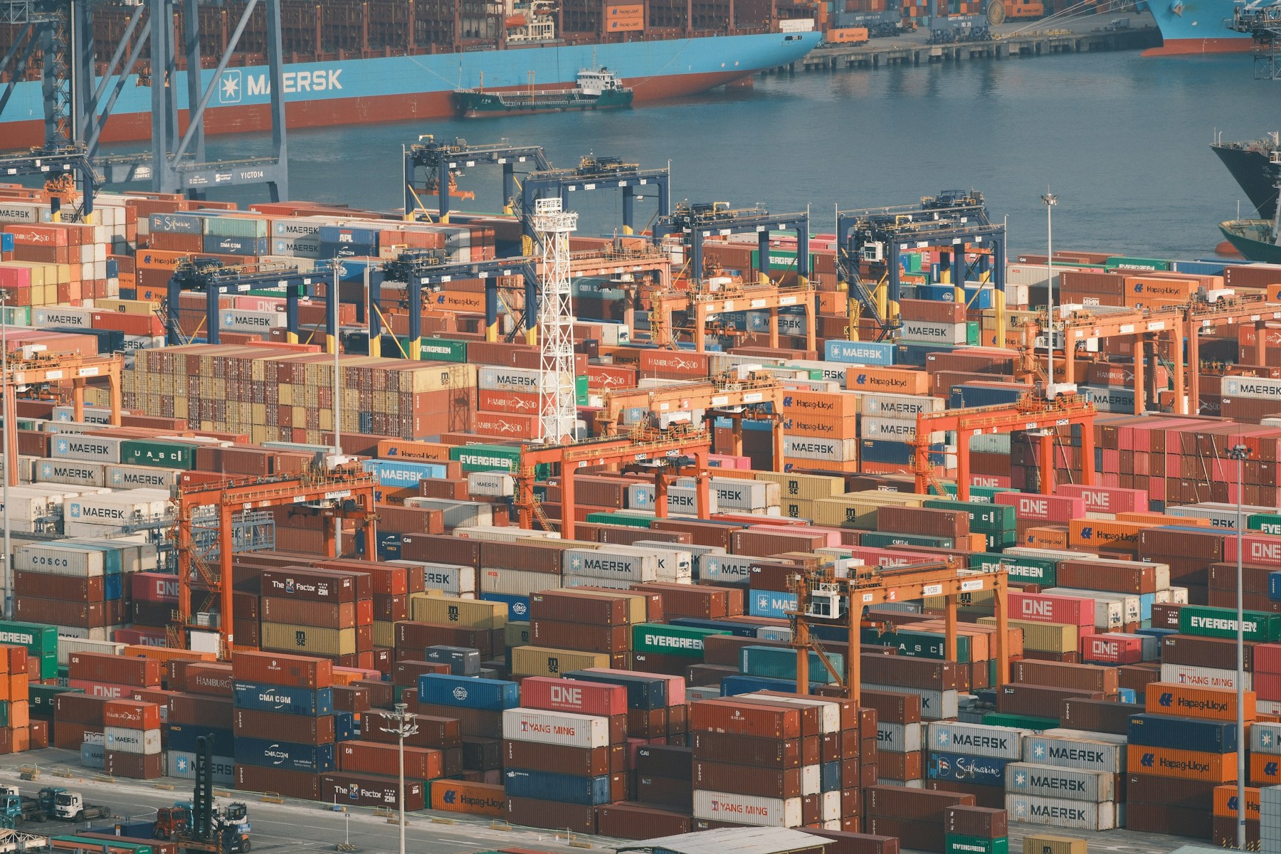 Container port with cargo vessels and freight cranes